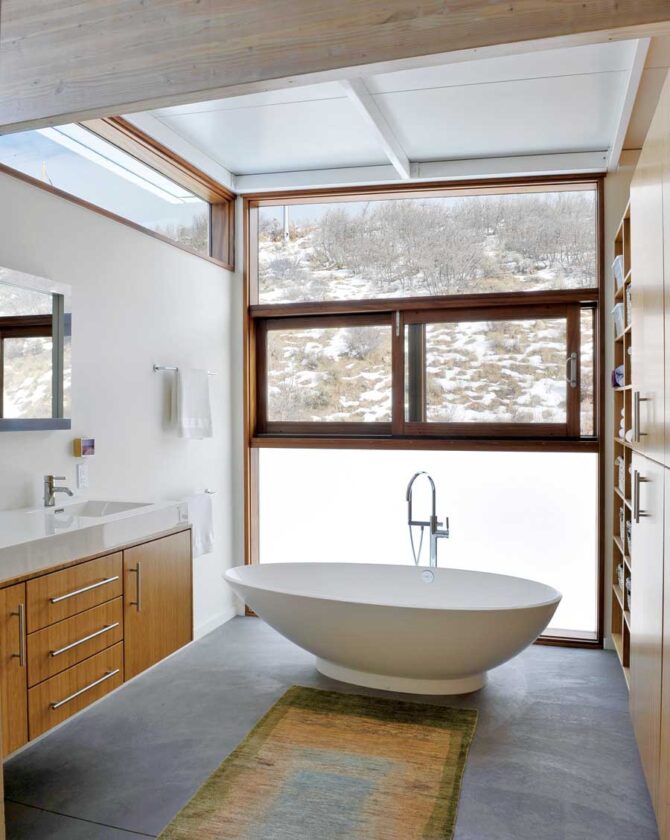 Multiple windows, built-in storage, polished concrete floors and a translucent panel make the bathroom bright, neat and private.
